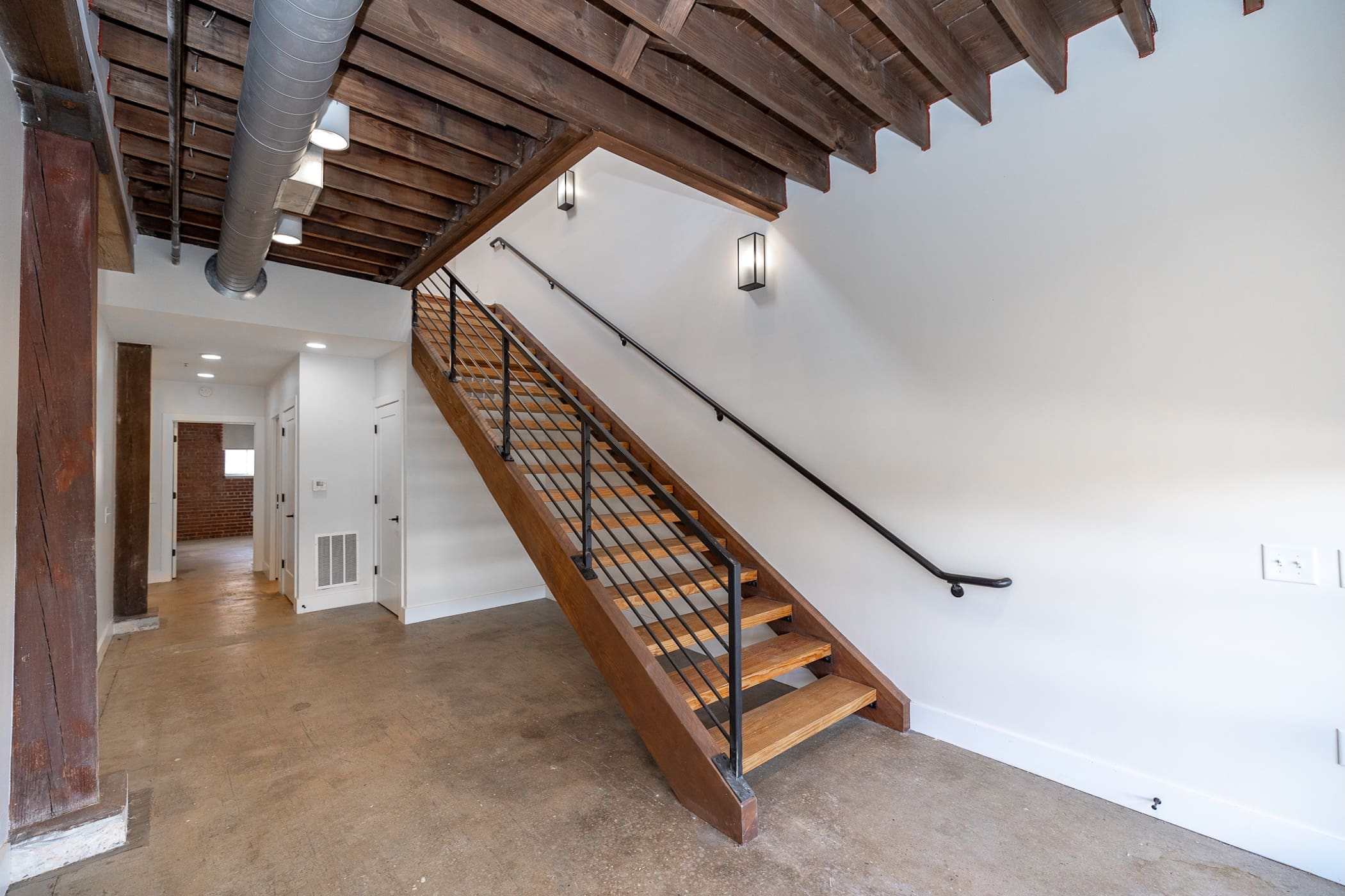 Lower-level unit nearing completion. Stair assembly complete. HVAC duct and electrical complete. Paint complete.