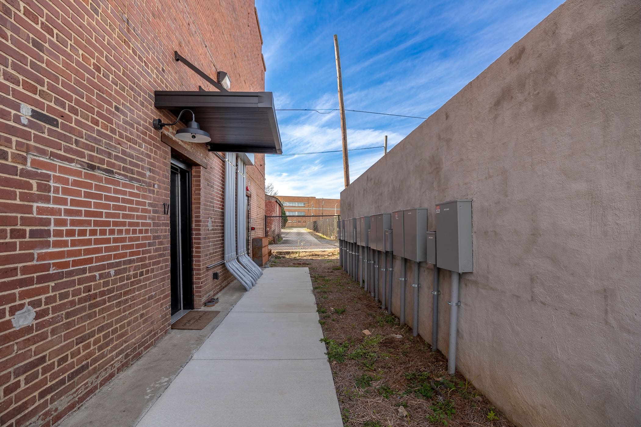 Rear elevation of “meter wall” reflecting routing of power to service the units. Note limited wall space available to mount electrical service.