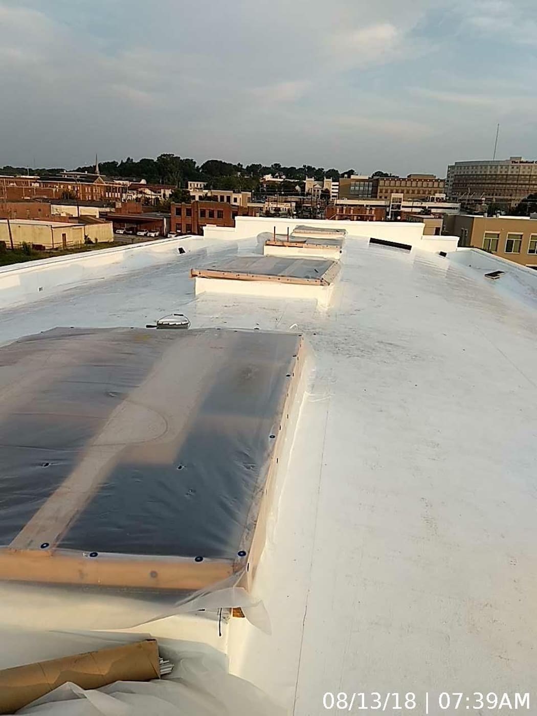Roof system repair complete and “dried-in” with new TPO roof including roof curbs for refurbished skylights.