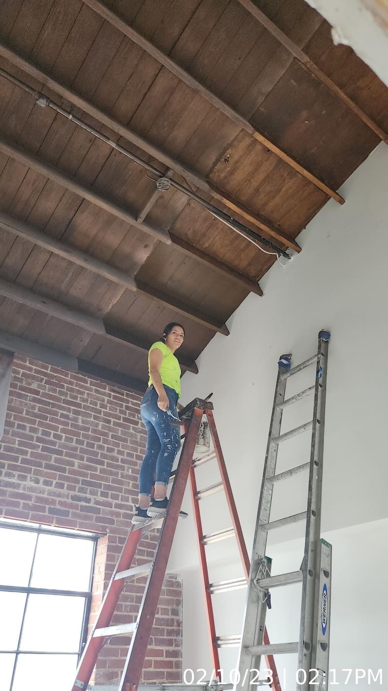 Painting contractor “graining” finish coat applied to intumescent paint to meet Historic Preservation requirements.